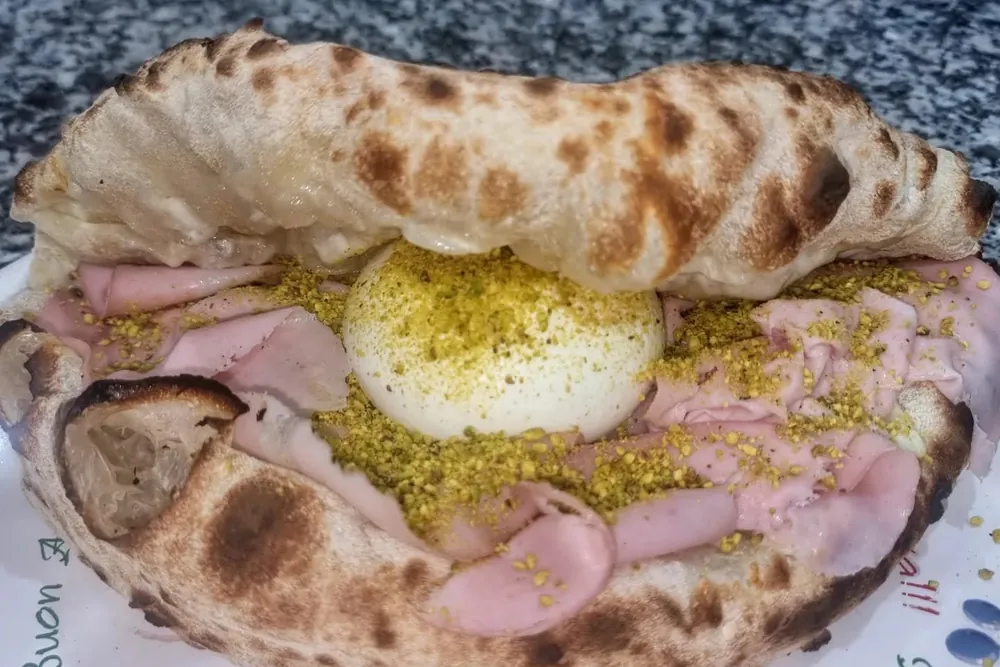 Una piadi-pizza chiusa con mortadella, burrata e pistacchio